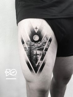 a man's thigh with a mountain scene on it and a clock in the sky