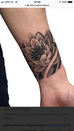 a black and white flower tattoo on the wrist