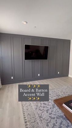 a living room with gray cabinets and a flat screen tv mounted on the back wall