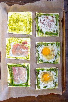 four different types of sushi with eggs in them on top of parchmented paper