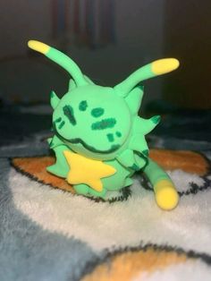 a green and yellow toy sitting on top of a rug