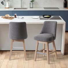 two gray chairs sitting on top of a kitchen counter next to a white countertop