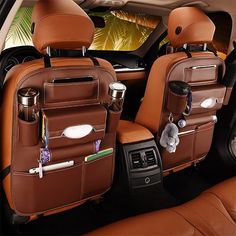 the interior of a car with two brown leather seats and one has an organizer in it