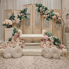 a wedding ceremony setup with flowers and greenery