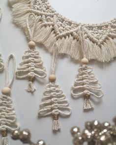 some white string and beads are hanging on a wall with silver sequins around it