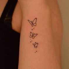 three butterflies tattoo on the left side of the right arm and behind the left arm