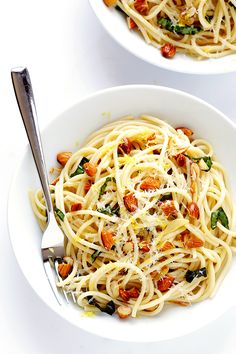 two white bowls filled with pasta and vegetables