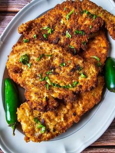 some fried food on a white plate with green peppers