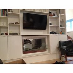 a living room filled with furniture and a flat screen tv mounted on the wall above a fire place