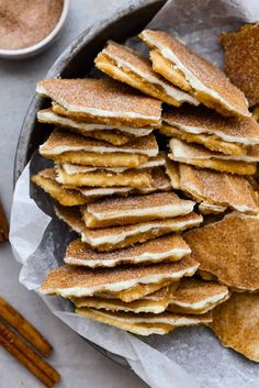 a pan filled with pancakes and cinnamon sticks