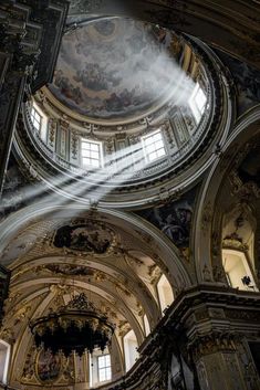 the light shines through the windows in an ornate building with painted ceilings and chandeliers