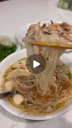 a bowl filled with noodles and meat on top of a table