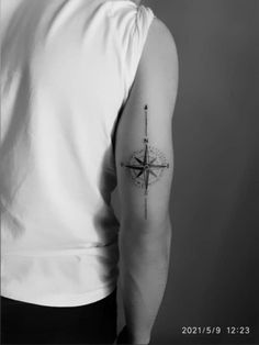 a man with a compass tattoo on his arm