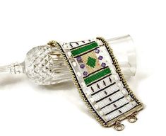 "Art Deco Loveliness! This cuff has an unusual look and construction.  This white Art Deco bracelet starts with a loomed strip of beautiful white, emerald green, amethyst purple and silver seed beads and flanked the edges with transluscent frosted crystal rondelles and tanzanite crystals.  To finish I edged it with a twisted rope of silver beads.   Finished with antiqued sterling silver over brass findings and pewter toggle clasps, giving the whole piece a vintage, Art Deco look.  Beadwork brace White Art Deco, Have A Happy Holiday, Bracelet Art, Beadwork Bracelet, Art Deco Bracelet, Beaded Cuff, Jewelry Statement, Bracelet Beaded, Amethyst Purple