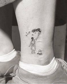 a person with a small tattoo on their ankle that has a drawing of a girl holding a kite