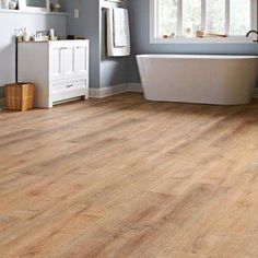 a bathroom with wood flooring and white bathtub in the middle of the room