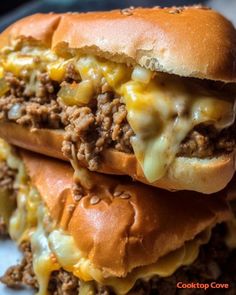 two cheeseburger sandwiches stacked on top of each other with melted cheese and ground beef