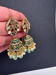 Krishna Jhumki Earrings pushback earringsColor : VictorianSize : Length : 2.5 Inches; Weight : 18grams eachStones : Red Green Stones Pearls Beads