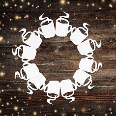 a paper cut out of a coffee cup in the shape of a wreath on top of a wooden table