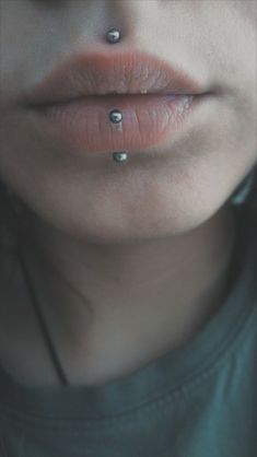 a woman's nose with three piercings on her lip and the bottom part of her mouth