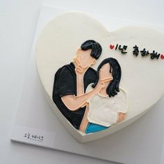 a cake shaped like a heart with an image of a man and woman on it