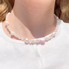 This is a beaded necklace I made that includes pink beaded accents! It is made up of pearls, and has a lobster claw in the back! I hope you love it :) Pink Pearl Chain Necklace With Round Beads, Pink Pearl Chain Beaded Necklaces With Round Beads, Pink Pearl Chain Beaded Necklace With Round Beads, Pink Beaded Necklaces With Pearl Charm, Handmade Pink Pearl Beaded Necklaces, Y2k Style Pink Beaded Necklace, Y2k Pink Beaded Necklaces, Trendy Pink Beaded Chain Necklaces, Pink Beaded Y2k Necklace