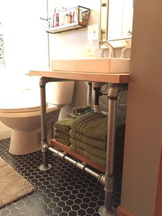 a bathroom with a sink, toilet and towel rack in the middle of the floor