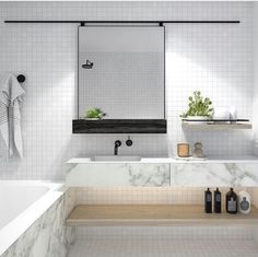 a white bathroom with marble counter tops and bathtub