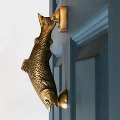 a door handle with a fish on it's side and a hook in the shape of a fish