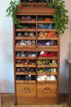 a large wooden cabinet filled with lots of yarn