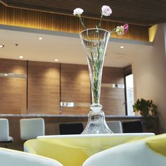 a vase filled with flowers sitting on top of a white chair in front of a table