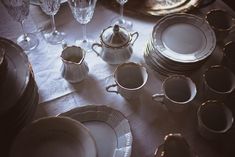 the table is set with dishes, cups and saucers for dinner guests to enjoy