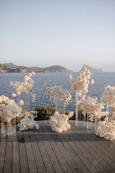 an outdoor ceremony setup with white flowers and clear acrylic vases