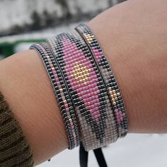 a close up of a person's arm wearing bracelets with beads on it