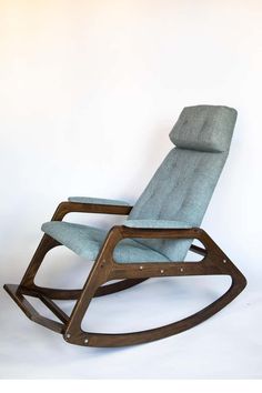 a wooden rocking chair with blue fabric on it