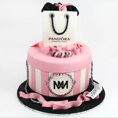 a pink and white cake with a shopping bag on top