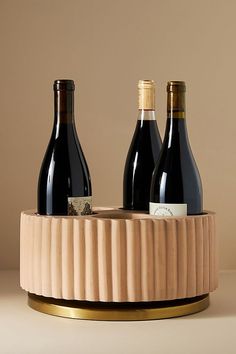 three bottles of wine in a wooden holder