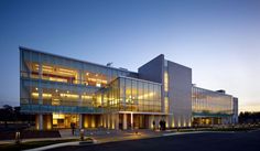 a large building with many windows and lights on it's sides at night time