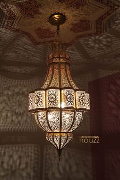 a chandelier hanging from the ceiling in a room with intricate designs on it