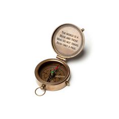 a compass with a keychain attached to it that says, the world is a book and those who do not travel read as well