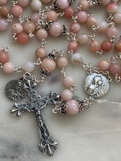 This rosary is handmade with 20 gauge Sterling wire and chain, sterling silver bead caps and sterling silver rosary medals.  The stones are 6 and 8mm pink opals. Silver Round Rosary For Spiritual Use, Silver Spiritual Rosary, Sterling Silver Spiritual Rosary With Crucifix, Spiritual Sterling Silver Crucifix Rosary, Handmade Silver Spiritual Rosary Bracelet, Handmade Silver Rosary Bracelet For Spiritual Use, Handmade Silver Rosary With Crucifix, Spiritual Sterling Silver Rosary With 8mm Beads, Handmade Silver Rosary With Round Beads