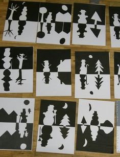 several black and white paper cut outs on a wooden table