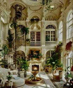 a living room filled with furniture and lots of windows next to a spiral stair case