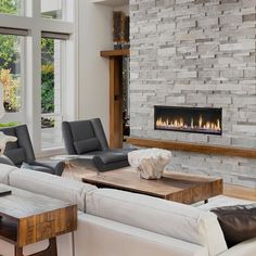 a living room filled with furniture and a fire place in the middle of it's wall