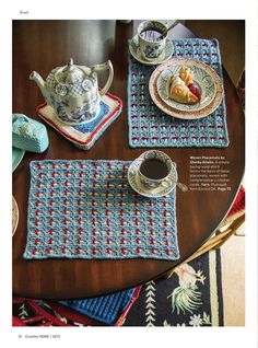 crocheted placemats and cups on a table with teapot, coffee cup, and plate