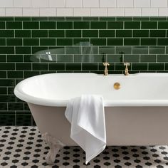 a white bath tub sitting on top of a black and white checkered tile floor