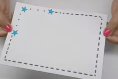 two hands holding a piece of paper with blue stars on it