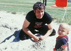 a man and child playing in the sand