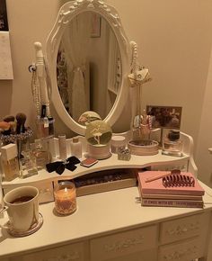 a white dresser topped with a mirror and lots of personal care items on top of it