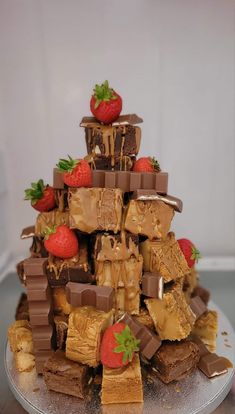 a cake made to look like a tower with chocolate, strawberries and other desserts